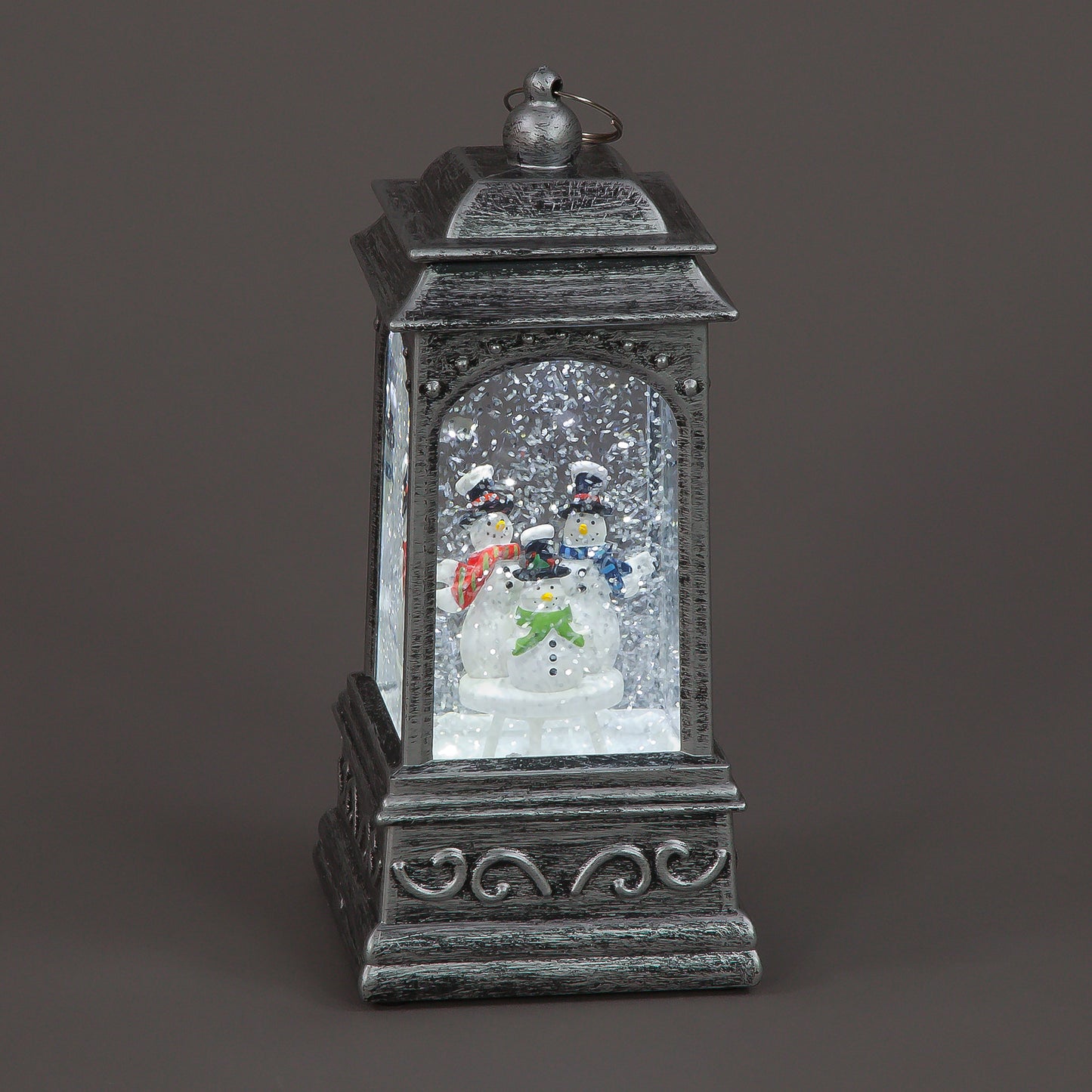 Decorative lantern with snowman and Christmas tree inside on a dark background