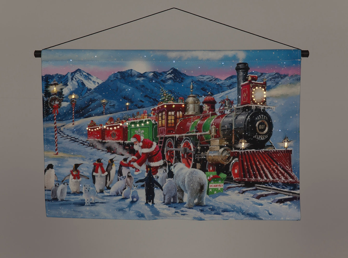 A battery-operated fiber optic hanging canvas featuring a Santa Claus express train with a Christmas theme, including snow and mountainous backdrop.