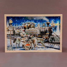 Framed artwork of a winter scene with a train, reindeer, and Santa Claus.